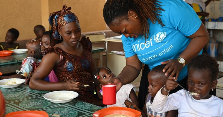unicef-medewerker geeft maaltijdvervanger aan kinderen