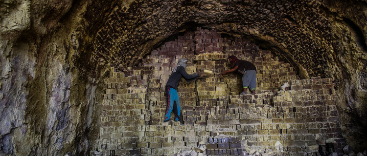 Twee jongen aan het werk in een Iraakse baksteenfabriek.