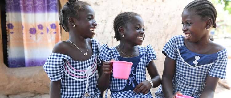Giggling school girls drinking water in côte d'ivoire