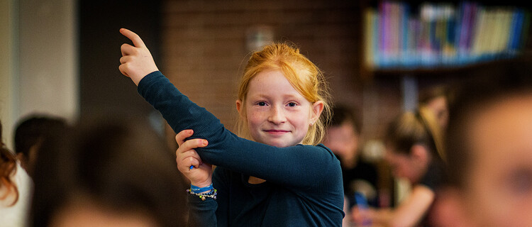 meisje in klas steekt vinger op