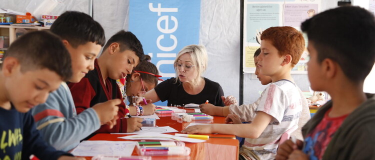 UNICEF medewerker met kinderen tijdens een psychosociale sessie