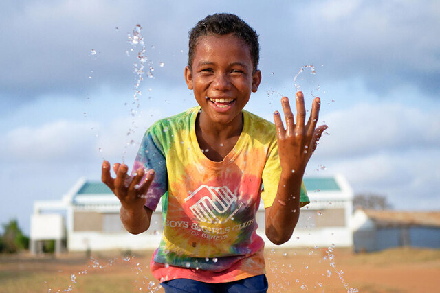 jongen spettert water en lacht in madagaskar